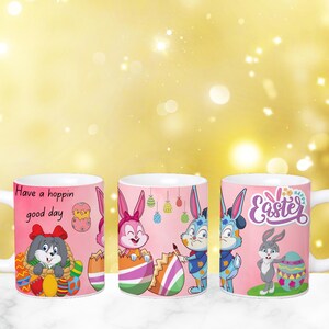 May include: Three pink ceramic mugs with Easter-themed designs. The mugs feature bunny rabbits, eggs, and the text "Have a hoppin' good day" and "Happy Easter".