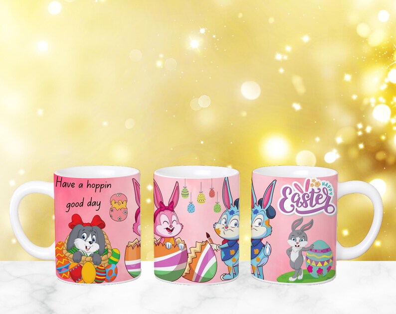 May include: Three pink ceramic mugs with Easter-themed designs. The mugs feature bunny rabbits, eggs, and the text "Have a hoppin' good day" and "Happy Easter".