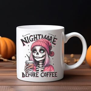 May include: White ceramic mug featuring a cartoon skeleton with pink hair and a pink beanie, holding a coffee cup. The mug has the text "NIGHTMARE BEFORE COFFEE" in black. The design is set against a wooden surface with pumpkins.