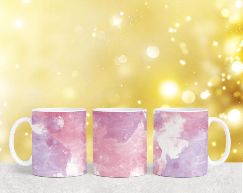 Puede incluir: Tres tazas de cer&aacute;mica con un dise&ntilde;o de estilo acuarela en tonos de rosa y morado. Las tazas tienen un fondo blanco y una asa blanca.