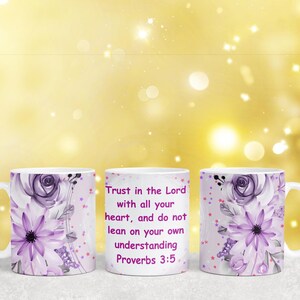 May include: Two white ceramic mugs with a purple floral design and gold glitter accents. The mug on the right has the text "Trust in the Lord with all your heart, and do not lean on your own understanding Proverbs 3:5" printed on it.