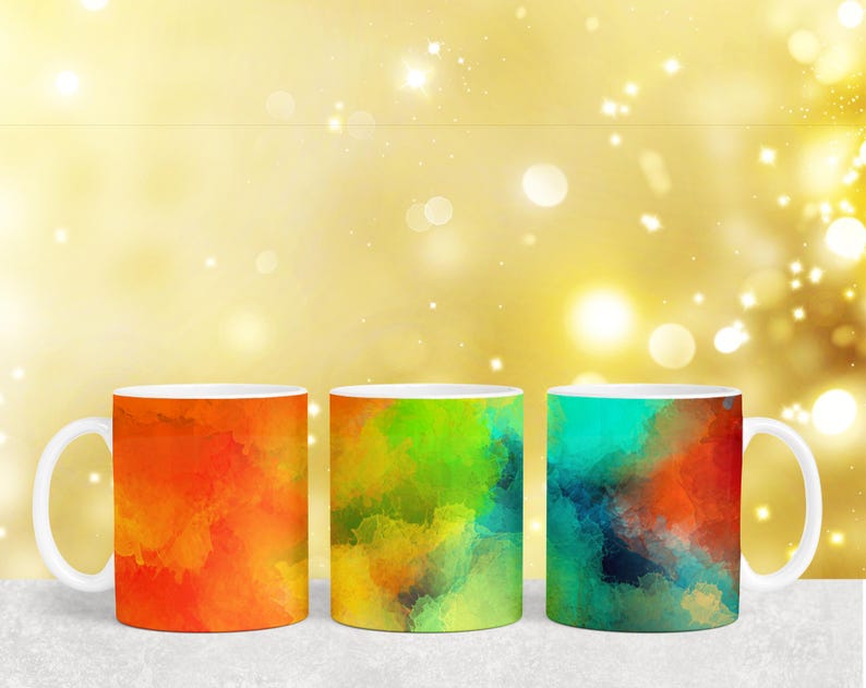 Puede incluir: Tres tazas de cer&aacute;mica con dise&ntilde;os abstractos de acuarela. Las tazas son naranja, verde y azul con fondo blanco.
