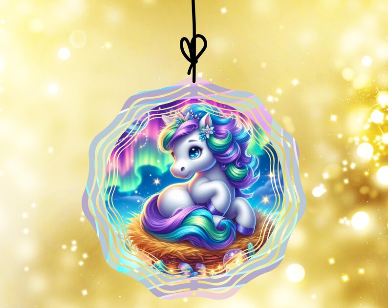 May include: A whimsical ornament featuring a white unicorn with a colorful mane and tail, nestled in a woven nest. The background showcases a vibrant aurora borealis scene, framed by a wavy, light purple border. A black string is attached for hanging.