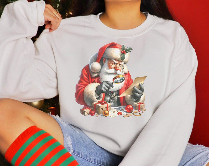 May include: White sweatshirt with a colorful illustration of Santa Claus looking through a magnifying glass at a list. The illustration includes presents, ornaments, and other Christmas decorations.