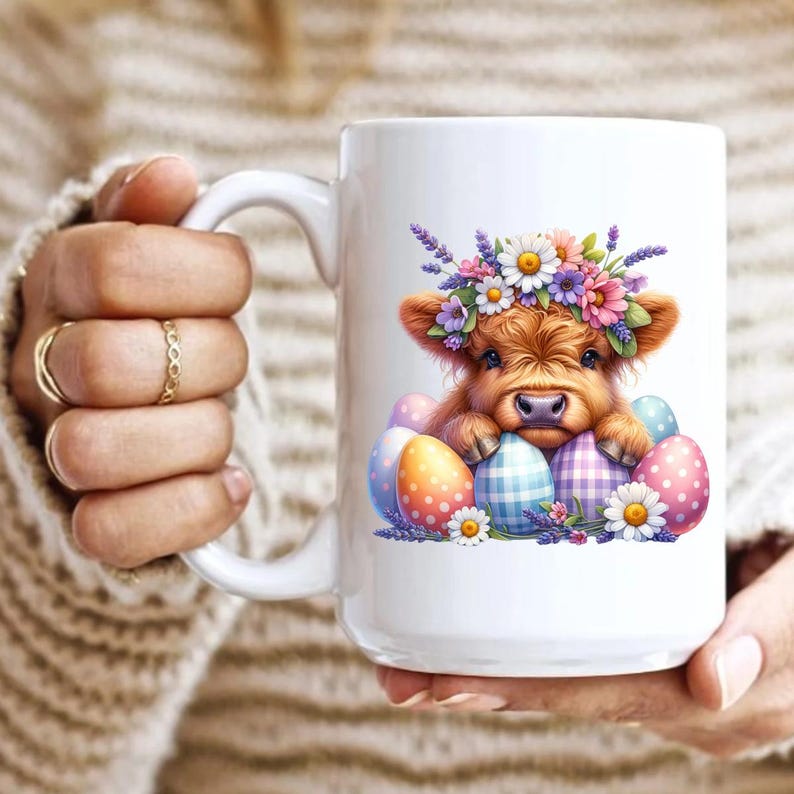 May include: White ceramic mug with a colorful illustration of a Highland cow wearing a flower crown and surrounded by Easter eggs.