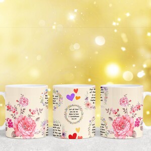 May include: Three white ceramic mugs with floral designs and inspirational quotes. The quotes are: "Let all that you do be done in love", "Be still and know that I am God", and "For the joy of the Lord is your strength".