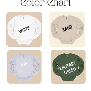 May include: Color chart featuring four crewneck sweatshirts in different colors: white, sand, ash, and military green. Each sweatshirt has a color name printed on it in a bold, sans-serif font.