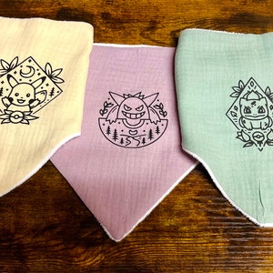 Puede incluir: Tres bandanas de tela con diferentes personajes de Pok&eacute;mon. La primera bandana es amarilla con un dise&ntilde;o de Pikachu. La segunda bandana es rosa con un dise&ntilde;o de Gengar. La tercera bandana es verde con un dise&ntilde;o de Bulbasaur.