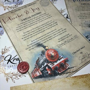 K&ouml;nnte beinhalten: Eine Einladung im Vintage-Stil mit dem Text &bdquo;Alle an Bord zum Nordpol&ldquo; und &bdquo;Phoebe & Ivy&ldquo;. Die Einladung zeigt eine Illustration eines roten und schwarzen Zuges und ein Wachssiegel. Der Text enth&auml;lt eine besondere Einladung.