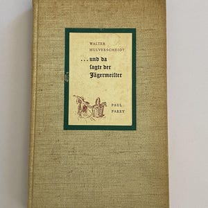 以下が含まれることがあります： テクスチャ加工された明るいタン色の表紙のヴィンテージ本。タイトル「...und da fagte der Jägermeister」は、緑色の長方形に黒い文字で表示されています。著者名、Walter Hulverscheidtも表示されています。