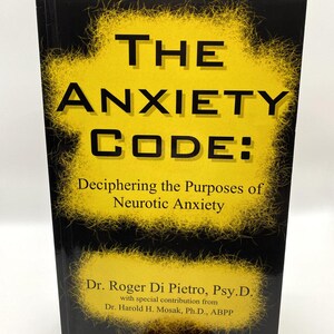 May include: A hardcover book titled "THE ANXIETY CODE: Deciphering the Purposes of Neurotic Anxiety." The cover features a yellow starburst design on a black background. The author is Dr. Roger Di Pietro, Psy.D.