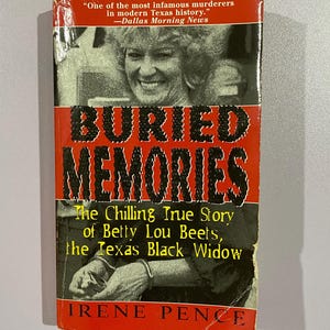 May include: A paperback book titled "Buried Memories" with a red and black cover. The cover features a black and white photo of a woman and the text "The Chilling True Story of Betty Lou Beets, the Texas Black Widow."