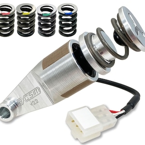 May include: A silver and brown metal shifter with a black wire and a white connector. The shifter has a label that reads "ECSM V22".