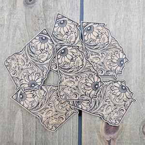 May include: Five beige vinyl stickers in the shape of the state of Georgia, each featuring a black and white floral design with a sunflower motif.