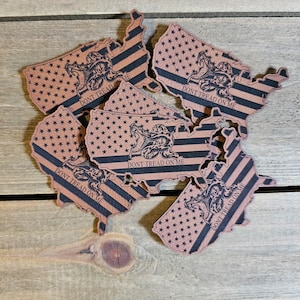 May include: Six brown leather US map-shaped patches with a black and white American flag design and the words "Don't Tread On Me" printed on each patch.