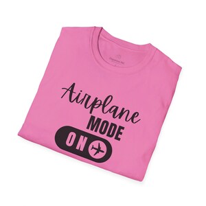 Pink t-shirt with black Airplane Mode ON design featuring a sliding switch graphic and plane icon.