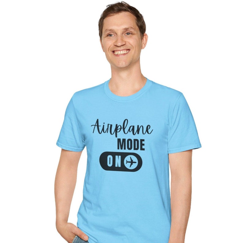 Light blue t-shirt with black Airplane Mode ON design featuring a sliding switch graphic and plane icon.