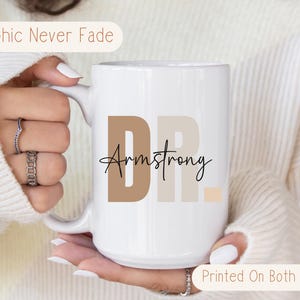 May include: White ceramic coffee mug with a brown, beige, and peach design that says "Dr. Armstrong" printed on both sides.