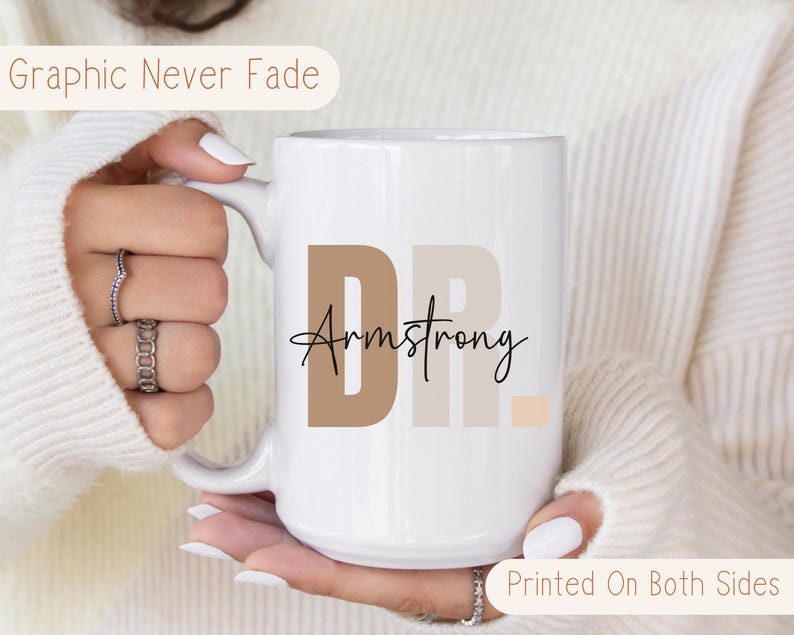 May include: White ceramic coffee mug with a brown, beige, and peach design that says "Dr. Armstrong" printed on both sides.