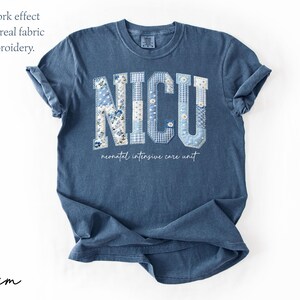 K&ouml;nnte beinhalten: Denimblaues T-Shirt mit dem Wort "NICU" in einem Patchwork-Design. Die Buchstaben sind mit verschiedenen blau-wei&szlig;en Blumen- und Vichy-Mustern gef&uuml;llt. Darunter steht der Text "neonatal intensive care unit".