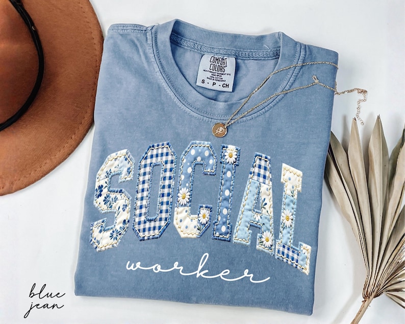 Blue Comfort Colors® t-shirt with "SOCIAL" in floral patchwork letters and worker script underneath, designed for social workers and mental health professionals.