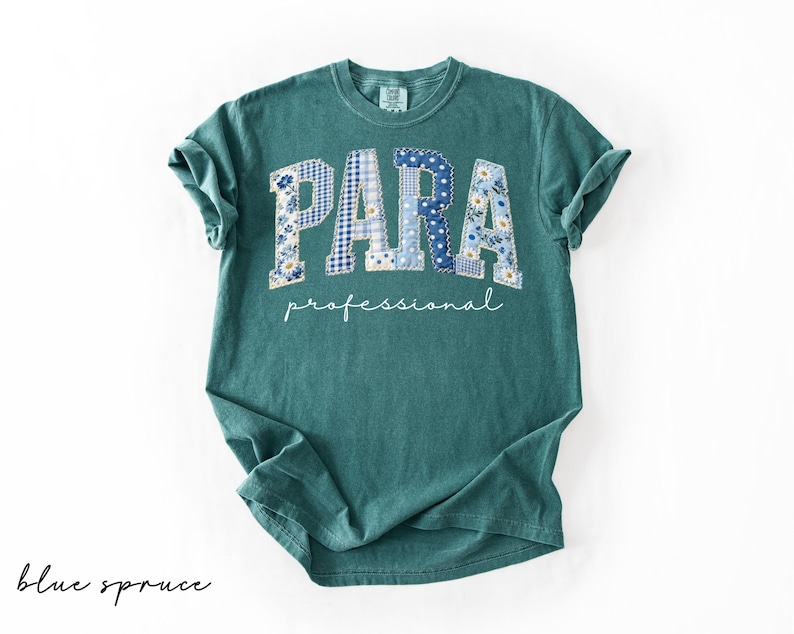 May include: A teal-colored t-shirt with the word "PARA" in large, patchwork-style letters, featuring blue floral and gingham patterns. Below, the word "professional" is written in a cursive font. The shirt is labeled "blue spruce" in the bottom left corner.
