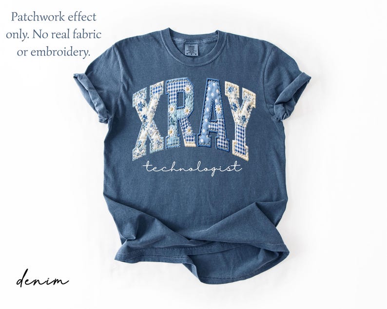 May include: Denim blue t-shirt with the word "XRAY" in a patchwork design, with floral and gingham patterns. The word "technologist" is written below in a script font. The shirt has rolled-up sleeves.