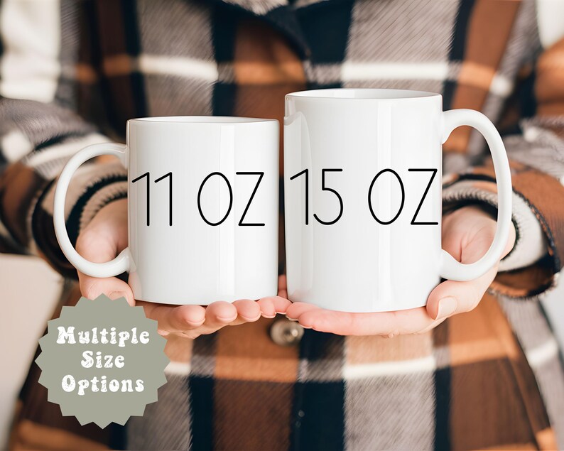 May include: Two white ceramic mugs with black text. The mug on the left says "11 oz" and the mug on the right says "15 oz".