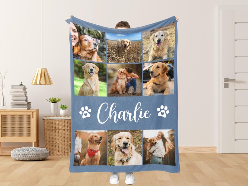 May include: A blue blanket featuring a collage of golden retriever photos. The blanket has the name "Charlie" in white script, along with paw print graphics. The photos show various golden retrievers in different settings.