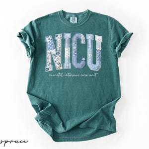 K&ouml;nnte beinhalten: Ein tealfarbenes T-Shirt mit den Buchstaben "NICU" in einem Patchwork-Design aus blauen Blumen- und Vichy-Mustern. Darunter steht der Text "neonatal intensive care unit".