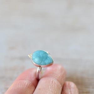 May include: A teardrop-shaped turquoise gemstone ring set in sterling silver with a gold accent.
