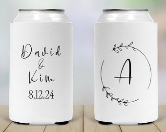 May include: Two white can coolers with black text. One cooler says "David & Kim 8.12.24". The other cooler has a circle with a leafy design and the letter "A" in the center.