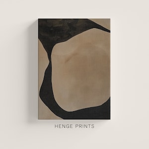 May include: Abstract art print featuring a large, organic shape in beige with a black outline. The shape is partially obscured by a smaller, black shape. The print has a textured canvas surface.