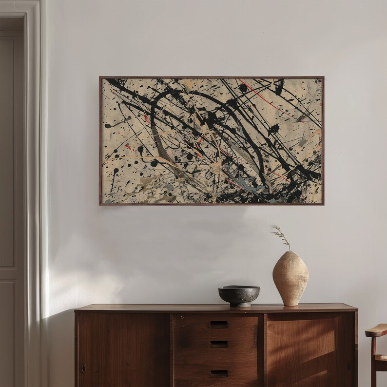 Pu&ograve; includere: Stampa d'arte astratta in una cornice marrone con schizzi di vernice nera, bianca e rossa su uno sfondo beige.