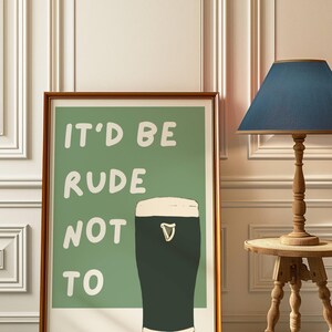 May include: A framed print with a green background and white text that reads "It'd be rude not to". A black and white illustration of a pint of Guinness is to the right of the text.