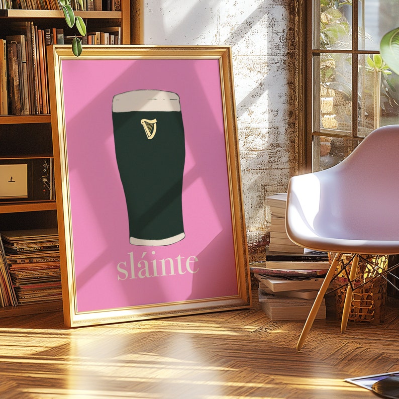 May include: A pink framed poster with a green pint glass of beer and the word "sl&aacute;inte" in white lettering.