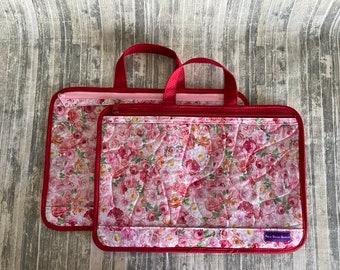 May include: Two red quilted zippered bags with floral patterns. The bags have pink zippers and red handles. The larger bag has the text "New Dawn Bags" on the bottom.