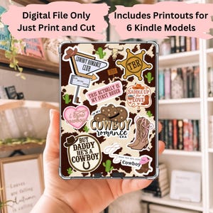 May include: A Kindle cover with a brown and white cowhide pattern, adorned with cowboy-themed stickers. The stickers include a cowboy hat, boots, and phrases like "Cowboy Romance Club" and "Saddle Up for Love." The text "Digital File Only" and "Includes Printouts for 6 Kindle Models" are also visible.