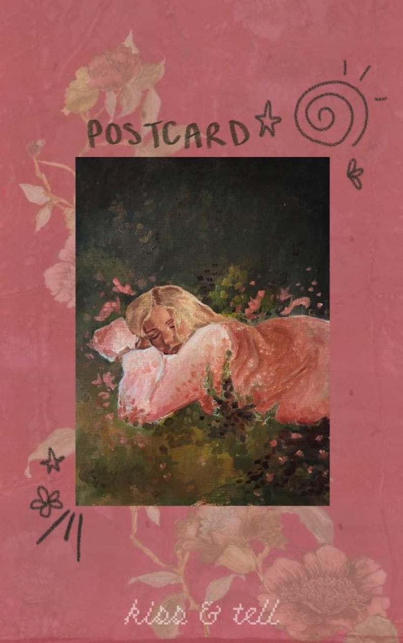 Op de afbeelding: Een rechthoekige ansichtkaart met een roze bloemenrand en de tekst POSTCARD en kiss & tell. Het midden toont een olieverfschilderij van een persoon met blond haar die op een wit kussen ligt in een donkergroen veld met roze bloemen.
