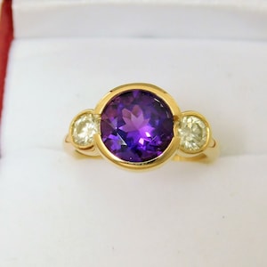 Siberian Amethyst 9mm round 2.50 Carats Three stone bezel 14K yellow gold ring w/ .60 carats of Diamonds  Available in Rose White gold 3004