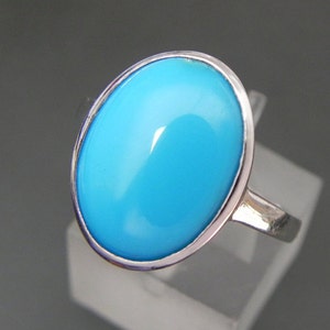 Puede incluir: Un anillo de plata con una gran piedra turquesa ovalada.