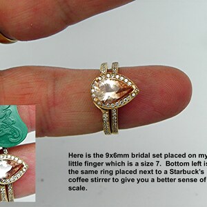 May include: A bridal set with a pear-shaped, light pink gemstone surrounded by smaller clear gemstones. The ring is on a finger and next to a coffee stirrer for size comparison.  The text "Here is the 9x6mm bridal set placed on my little finger which is a size 7. Bottom left is the same ring placed next to a Starbucks coffee stirrer to give you a better sense of scale." is visible below the ring.