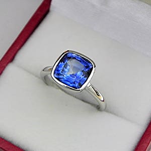 Zafiro azul AAAA talla cojín de 8 x 8 mm y 2,85 quilates en anillo de compromiso de oro blanco de 14 quilates. MMM
