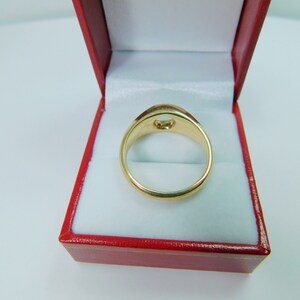 K&ouml;nnte beinhalten: Ein goldener Ring mit einer runden, leeren Fassung in einer roten Samt-Ringbox.