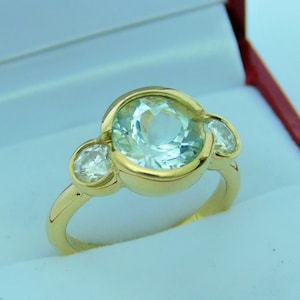 AAA Aquamarine 9mm  2.64 Carats Three stone bezel 14K yellow gold ring w/ .60 carats of Diamonds  Available in Rose White gold 3021
