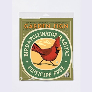 May include: A garden sign featuring a red cardinal bird illustration. The sign reads "Garden Sign" and "Bird & Pollinator Habitat, Pesticide Free". The sign is in a plastic sleeve.