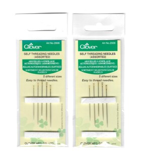 May include: Two identical packages of Clover brand self-threading needles, Art No. 2006. Each clear plastic hanging packet contains five silver-colored needles of different sizes with gold-toned eyes, secured by two white foam strips on a green card.