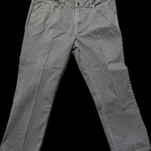 Może przedstawiać: Szare dżinsy. Dżinsy mają klasyczny pięciokieszeniowy design, zapięcie na guzik i zamek błyskawiczny oraz szlufki na pasek. Spodnie są wykonane z wytrzymałego materiału i mają prosty krój nogawki.