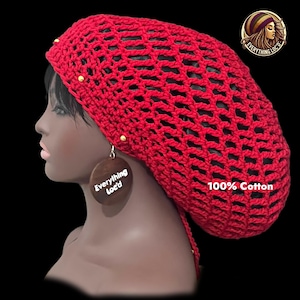 Peut inclure: Un bonnet rouge en crochet avec des accents dorés et un cordon de serrage assorti. Le chapeau est fait de 100% coton. Le modèle porte des boucles d'oreilles en bois avec le texte "Everything Loc'd".