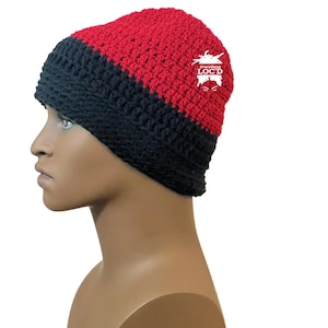 May include: A handmade crochet beanie in red and black. The hat features a horizontal color block design with the red section on top and the black section on the bottom. The text "Everything LOC'D" is printed on the side.